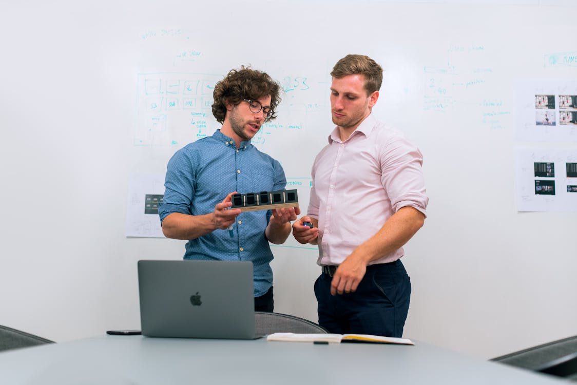 Engineers collaborating over a prototype in a meeting room